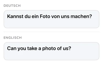 Satzfeld mit der deutschen Phrase und ihrer englischen Übersetzung „Can you take a photo of us?“