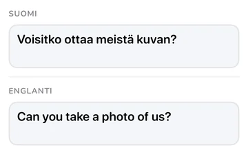 Fraasipaneeli, jossa suomenkielinen ”Voisitko ottaa meistä kuvan?” ja englanninkielinen käännös ”Can you take a photo of us?”