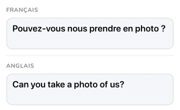 Panneau de phrase avec la phrase française et sa traduction anglaise « Can you take a photo of us? »