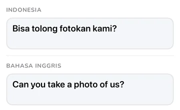Panel frasa dengan frasa bahasa Indonesia dan terjemahan bahasa Inggrisnya “Can you take a photo of us?”