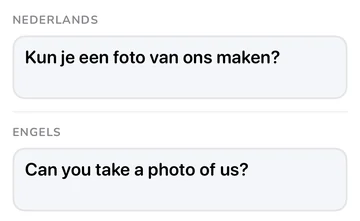 Zinspaneel met de Nederlandse zin en de Engelse vertaling “Can you take a photo of us?”